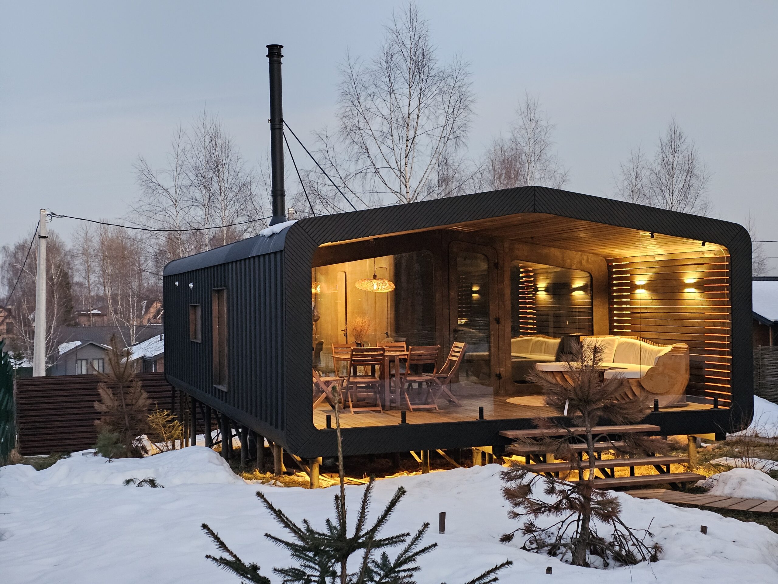 Built BARN 57 cabin with illuminated covered terrace at dusk