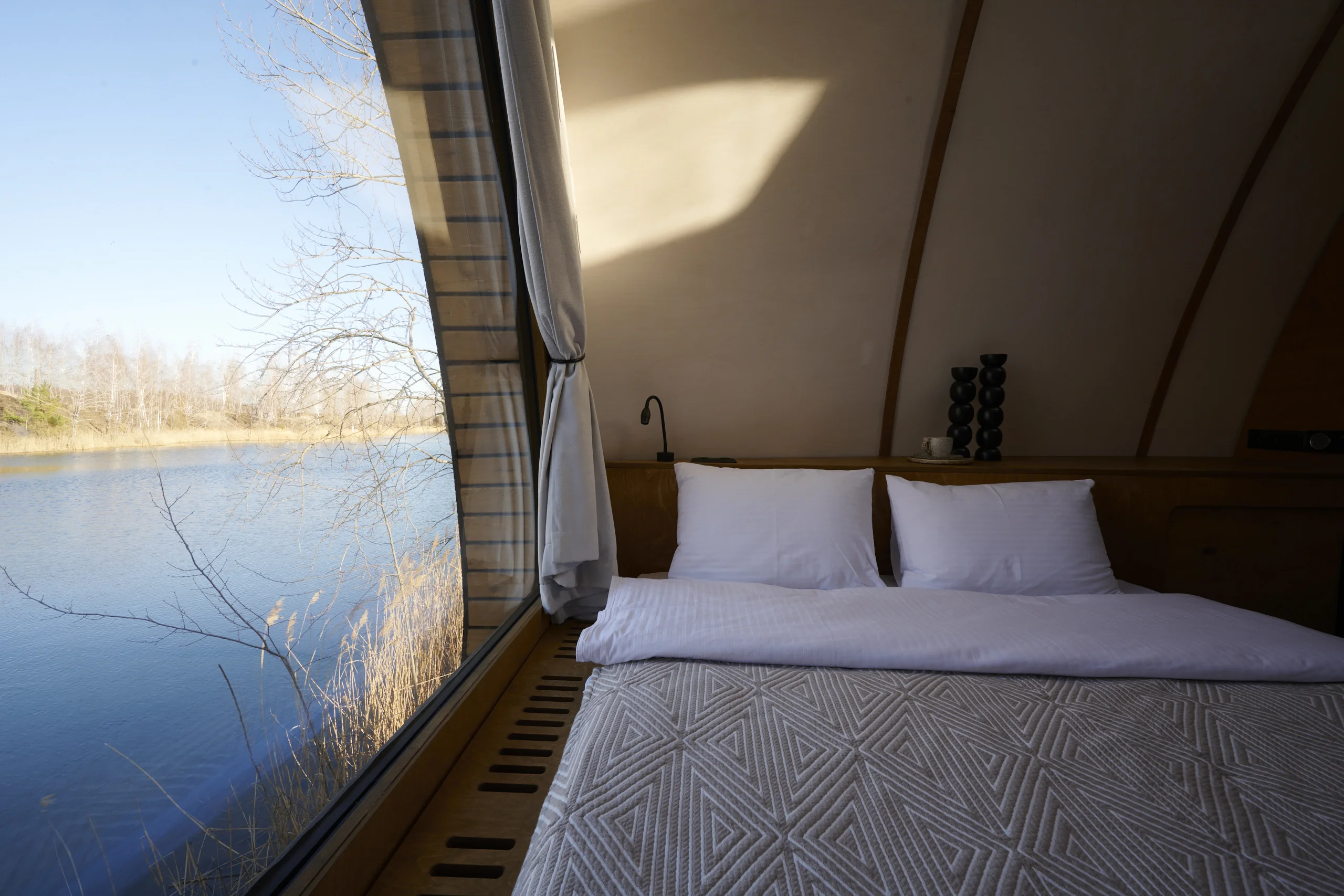 HIZ sleeping area beside panoramic glazing overlooking water