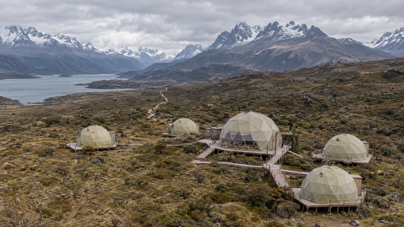 Illustrative dome camp layout in a mountain steppe, with guest domes linked by boardwalks to a shared dome and walking trail