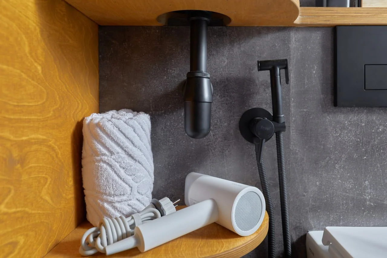 Cabin bathroom fit-out with sink plumbing and a handheld fixture visible